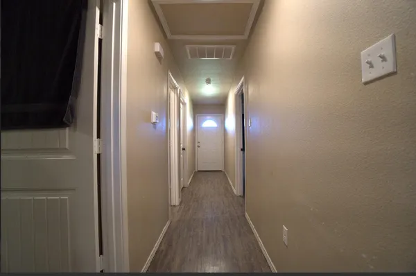 a view of a hallway with wooden floor