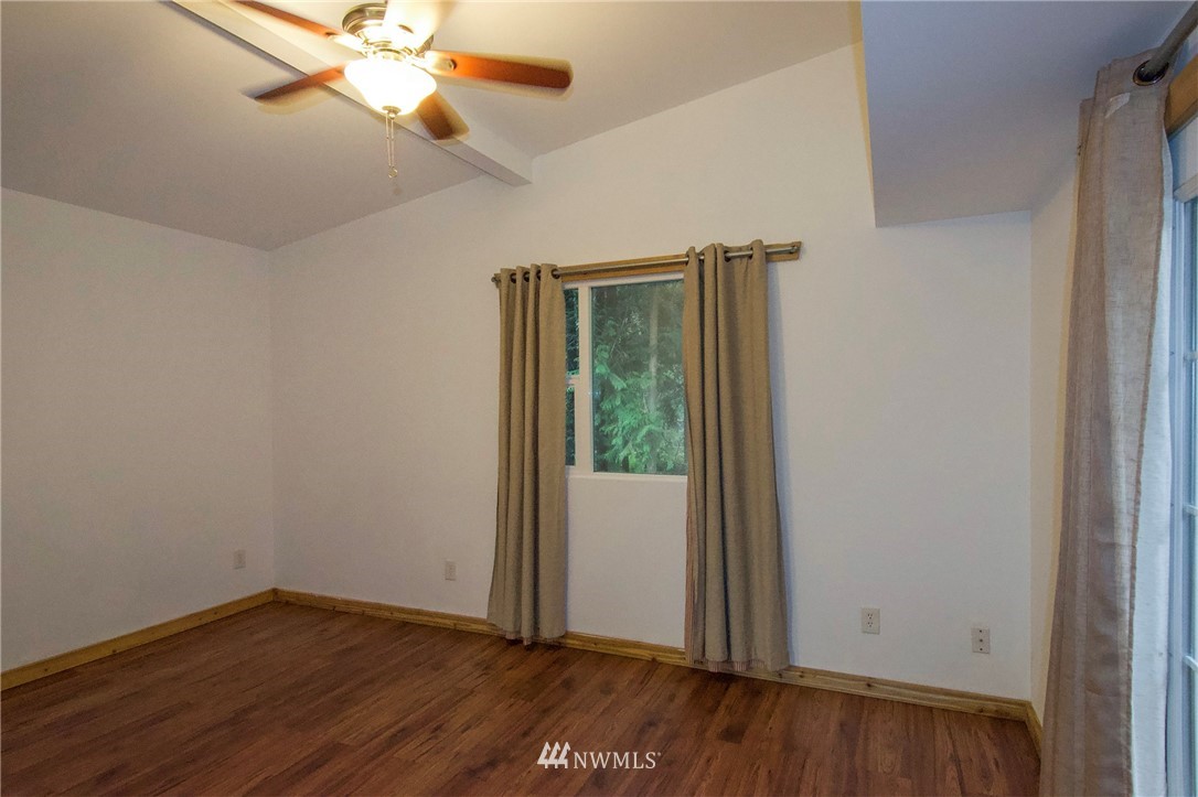 463 Autumn Road Sequim, WA 98382 - Photo 18 of 40 an empty room with wooden floor fan and windows