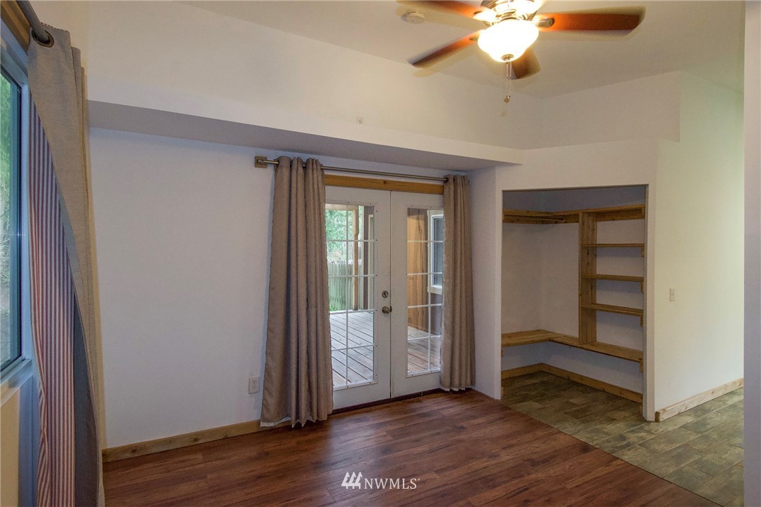 463 Autumn Road Sequim, WA 98382 - Photo 19 of 40 an empty room with wooden floor chandelier fan and closet area
