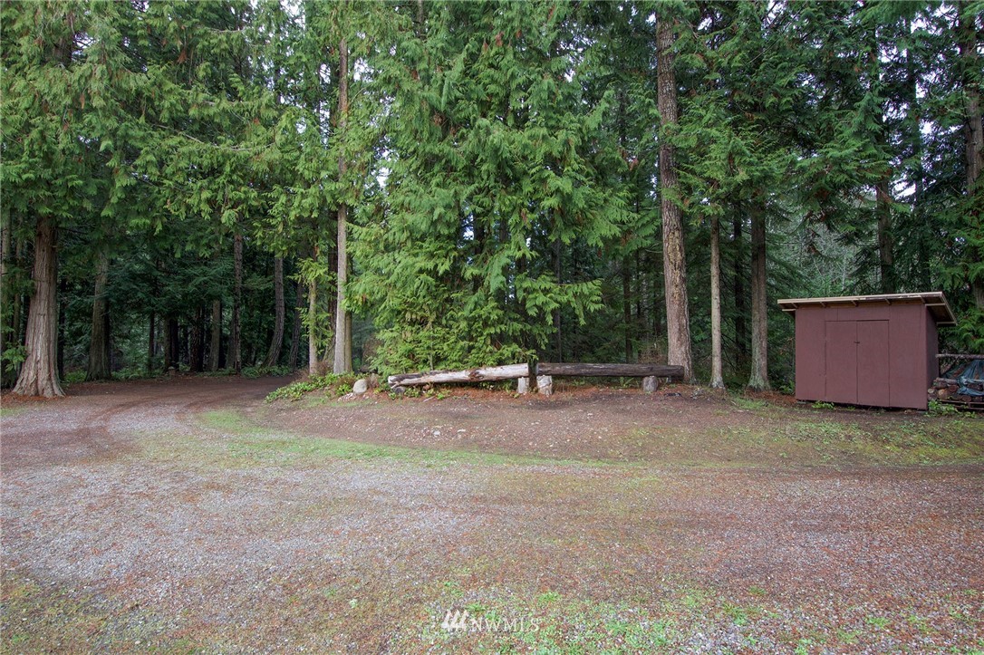 463 Autumn Road Sequim, WA 98382 - Photo 35 of 40 a backyard of a house with large trees and plants