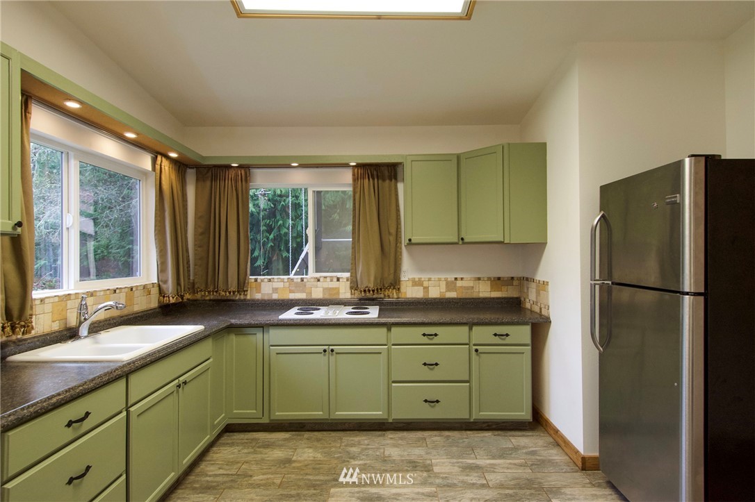 463 Autumn Road Sequim, WA 98382 - Photo 10 of 40 a kitchen with a sink a refrigerator and windows
