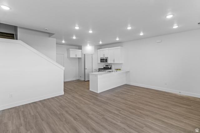 2995 South 265th Street West, Unit 752 Logan, UT 84321 - Photo 4 of 21 Open-concept living space featuring wood-finish flooring, recessed lighting, and a modern kitchen