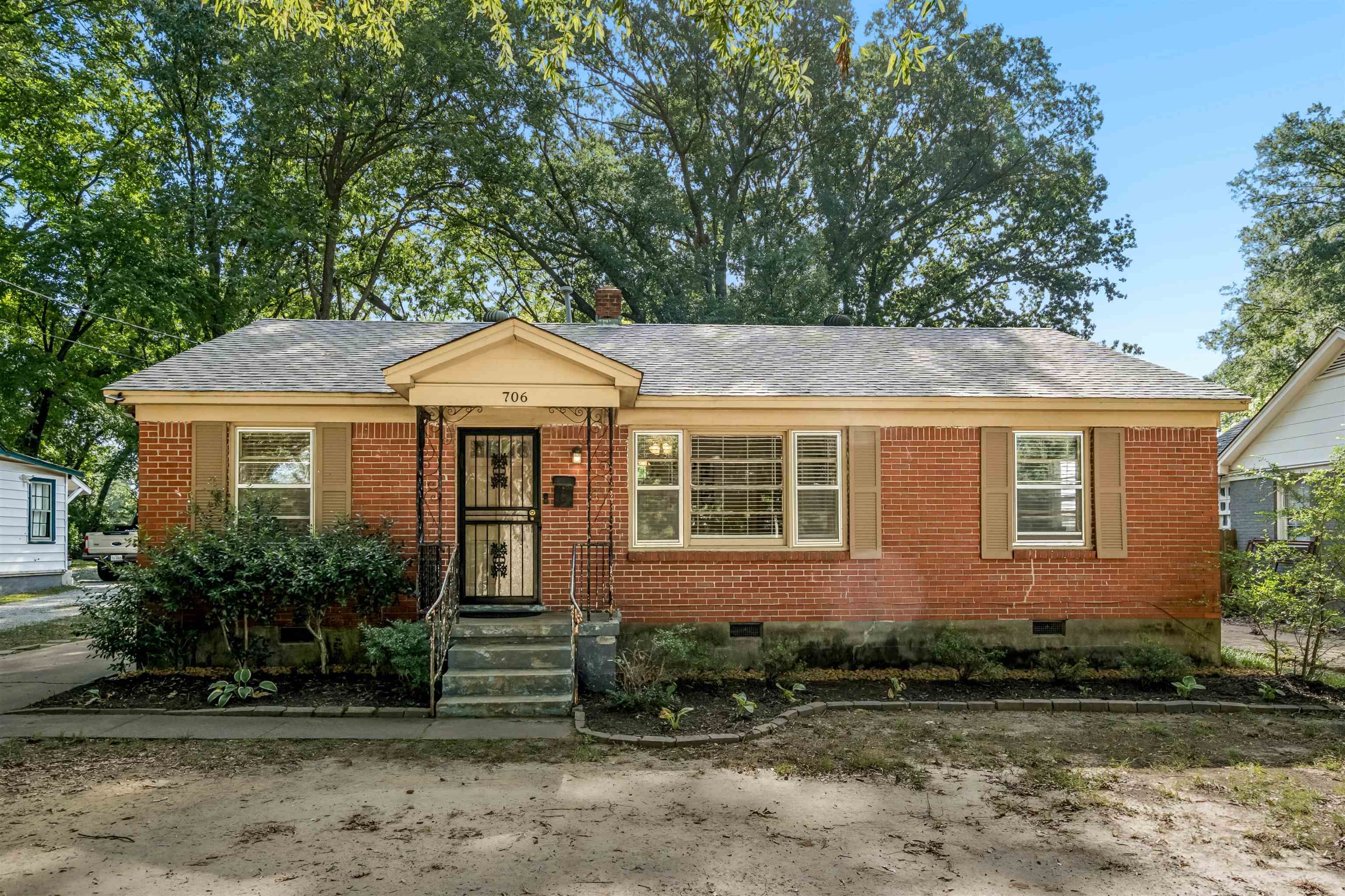 706 North Perkins Road Memphis, TN 38122 - Photo 1 of 20 Brick exterior with a gabled entry, wood shutters, and an asphalt shingle roof