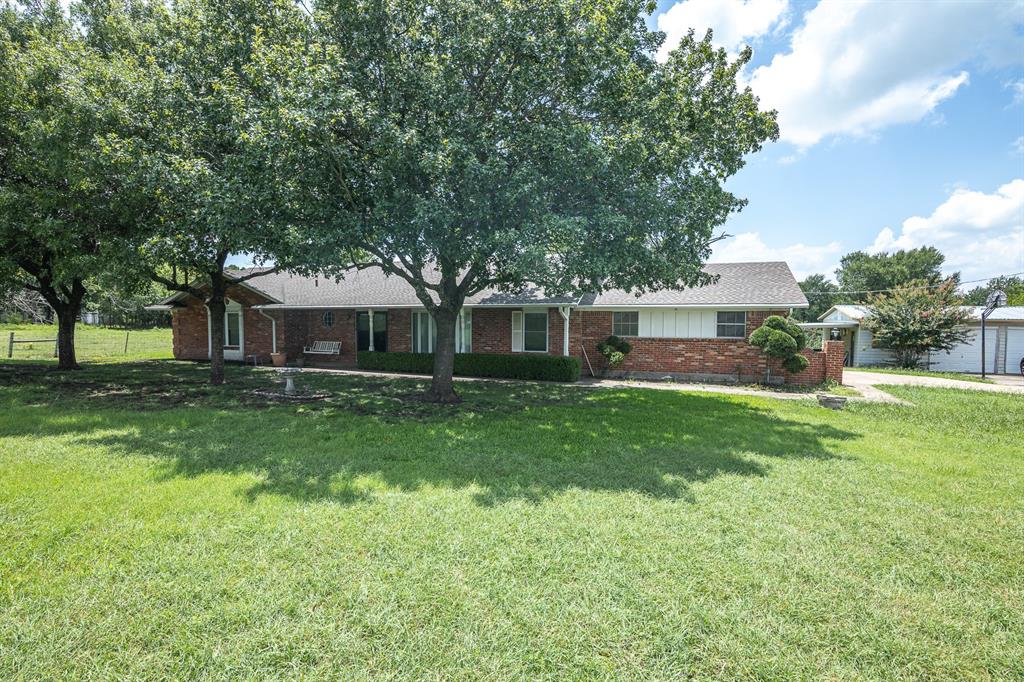 Ranch-style house featuring brick siding, a garage, and roof with shingles