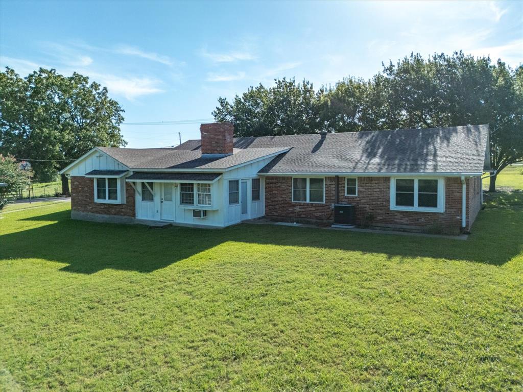 2690 Kelly Road Aledo, TX 76008 - Photo 5 of 19 Back of property with a yard, a chimney, board and batten siding, and brick siding