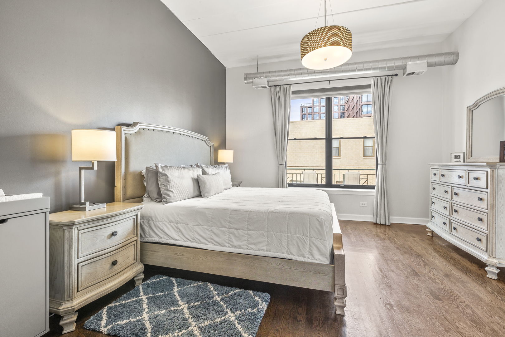 936 West Madison Street, Unit E4 Chicago, IL 60607 - Photo 13 of 21 a bedroom with a bed and dresser with mirror