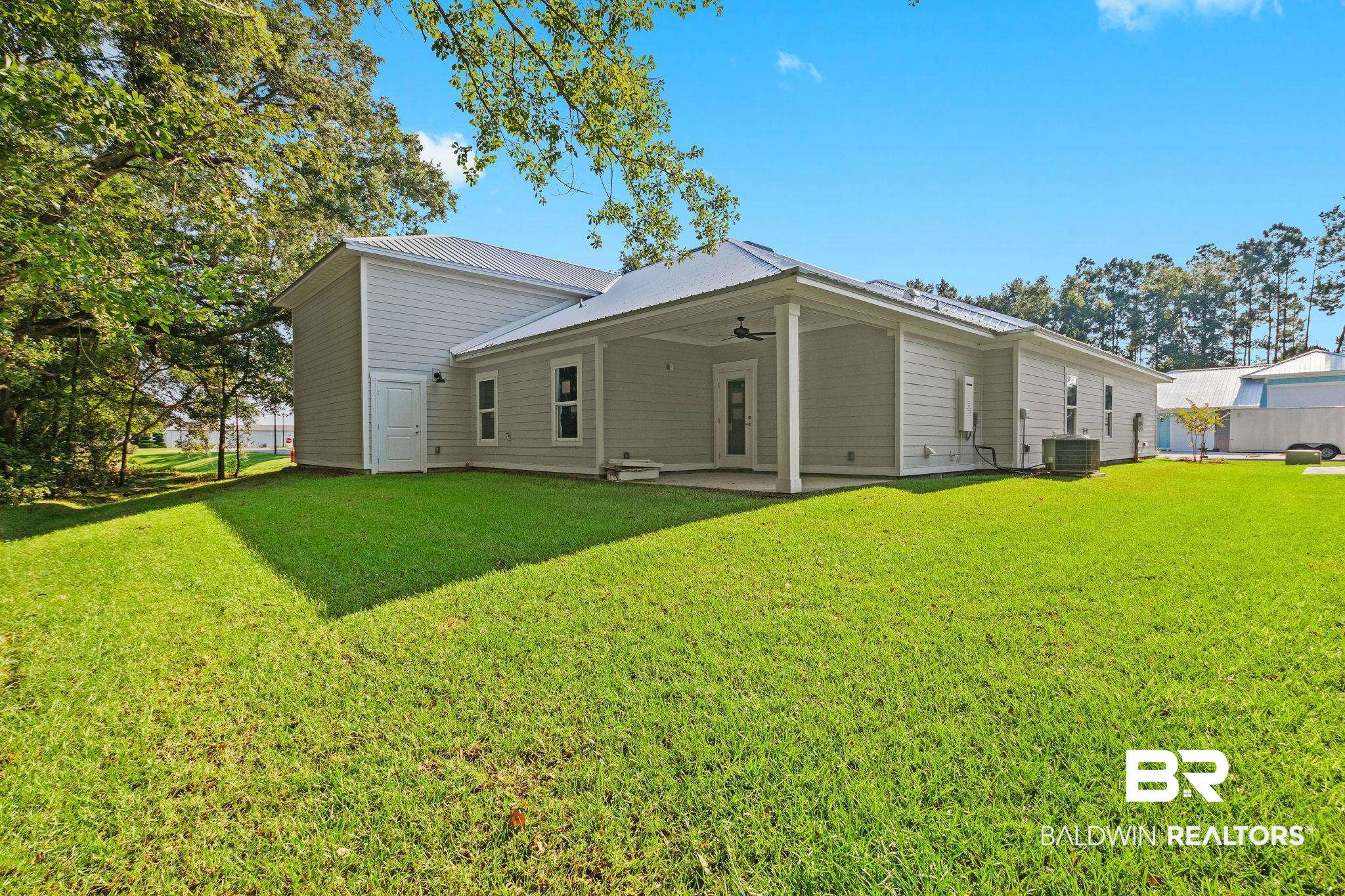 12441 Reunion Place Foley, AL 36535 - Photo 31 of 31 Rear view of property featuring a lawn, a patio area, central AC unit, and ceiling fan
