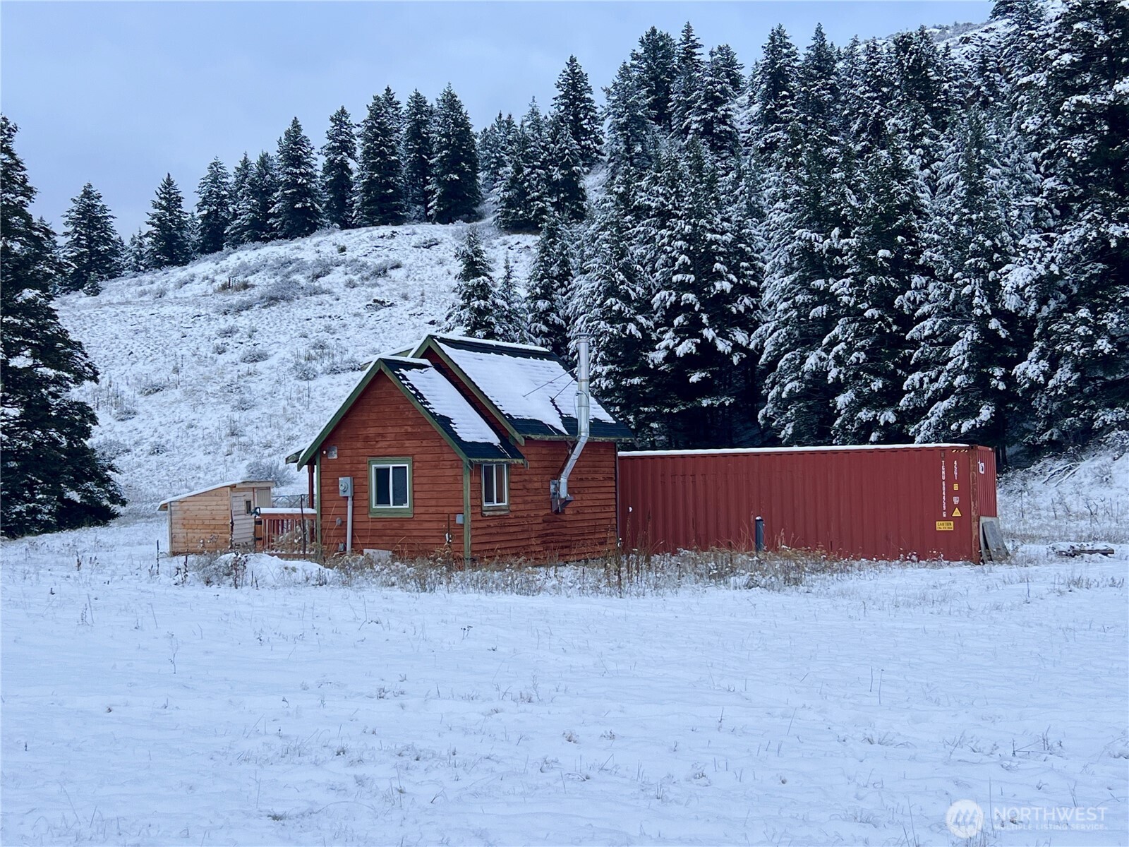 2 Mountain View Drive Oroville, WA 98844 - Photo 3 of 26 a view of wooden house with a yard and trees in the background