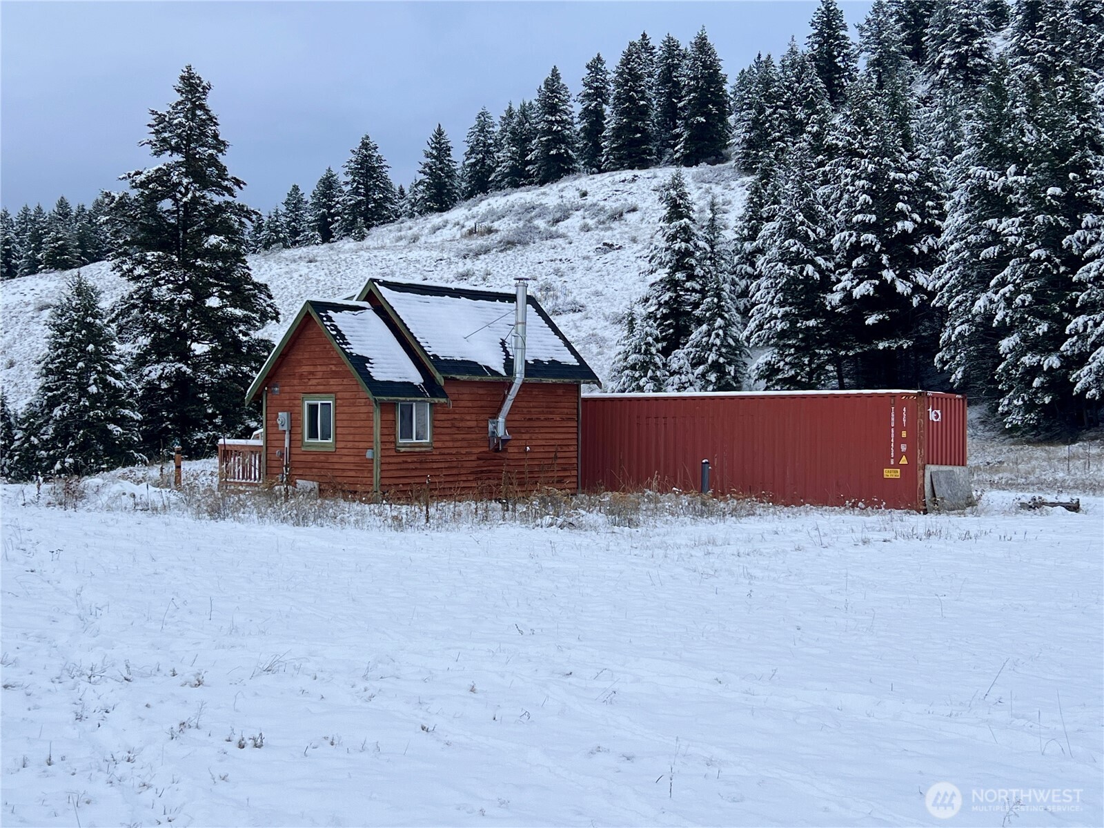 2 Mountain View Drive Oroville, WA 98844 - Photo 4 of 26 a view of wooden house with a snow in the yard