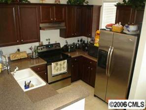 152 Singleton Road Mooresville, NC 28117 - Photo 4 of 6 a kitchen with granite countertop a refrigerator and a stove top oven