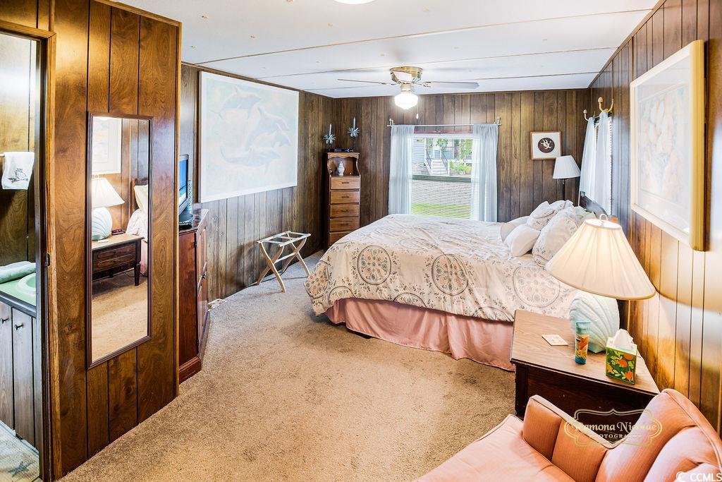 298 Flamingo Surfside Beach, SC 29575 - Photo 2 of 31 Carpeted bedroom featuring wood walls and a ceiling fan