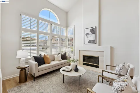a living room with furniture a fireplace and a large window
