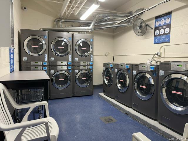 1332 Metropolitan Avenue, Unit 6A Bronx, NY 10462 - Photo 11 of 11 Communal laundry room featuring concrete block wall, washing machine and dryer, and stacked washer / dryer