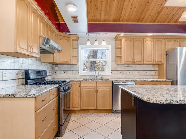 a kitchen with stainless steel appliances granite countertop a sink stove and cabinets