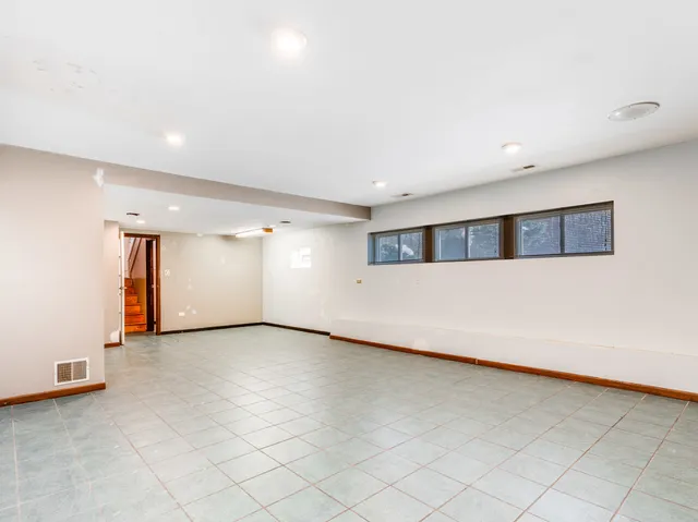a view of an empty room with window and stairs