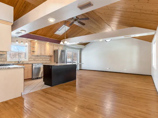 a kitchen with stainless steel appliances granite countertop a sink counter space and wooden floor