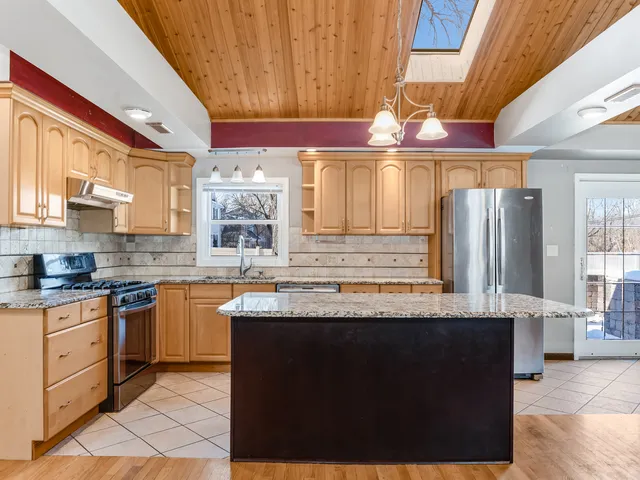 a kitchen with granite countertop a sink and cabinets