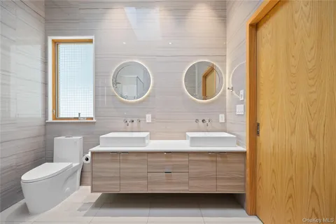 a bathroom with a double vanity sink mirror and toilet