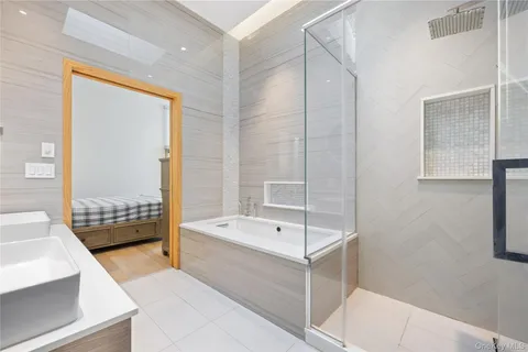 a bathroom with a tub a sink and a large mirror