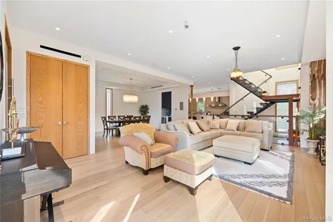 a living room with couches and kitchen view with wooden floor