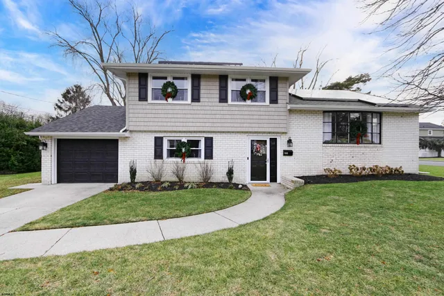 a front view of a house with a garden and yard