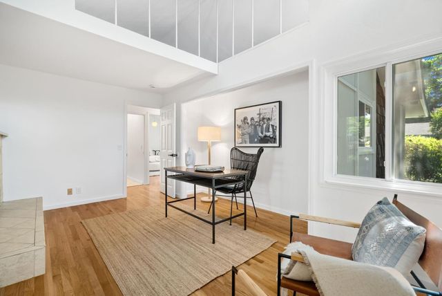 a view of a white house with potted plants and a fountain