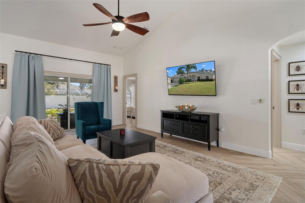 11370 Terrell Road Spring Hill, FL 34608 - Photo 16 of 54 a living room with furniture a desk and a flat screen tv