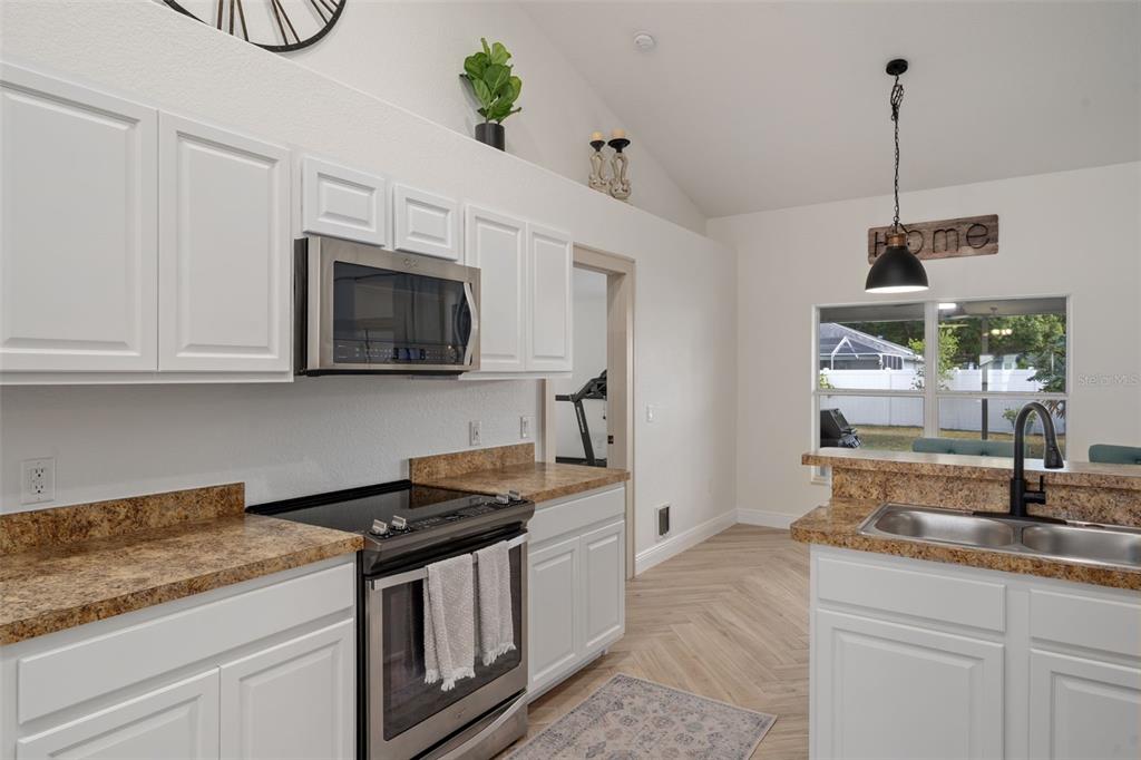 11370 Terrell Road Spring Hill, FL 34608 - Photo 20 of 54 a kitchen with stainless steel appliances granite countertop a sink a stove and a microwave