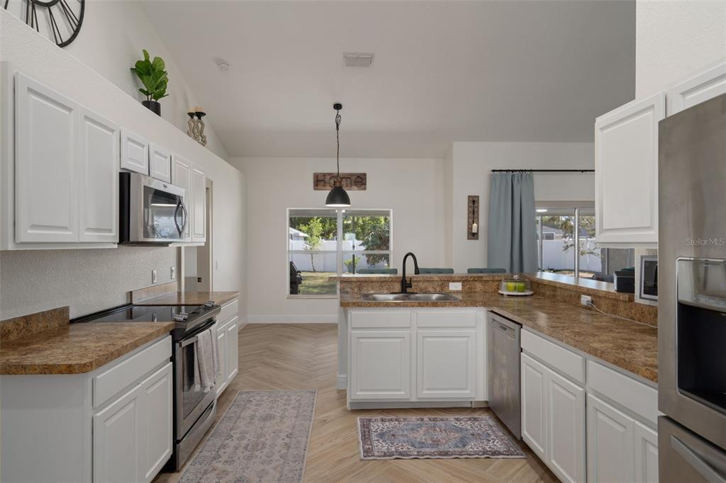 11370 Terrell Road Spring Hill, FL 34608 - Photo 21 of 54 a kitchen with stainless steel appliances granite countertop a sink stove and refrigerator
