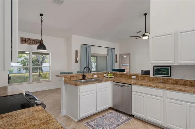 a kitchen with stainless steel appliances granite countertop a table and chairs in it