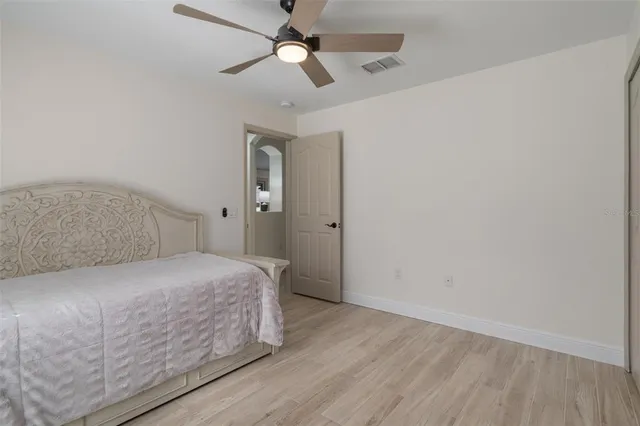 a bedroom with a bed and wooden floor