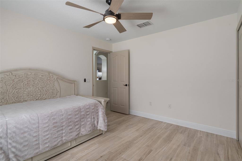 11370 Terrell Road Spring Hill, FL 34608 - Photo 34 of 54 a bedroom with a bed and a chandelier fan