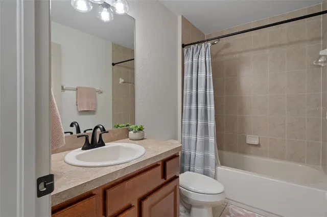 a living room with furniture a floor to ceiling window and stainless steel appliances