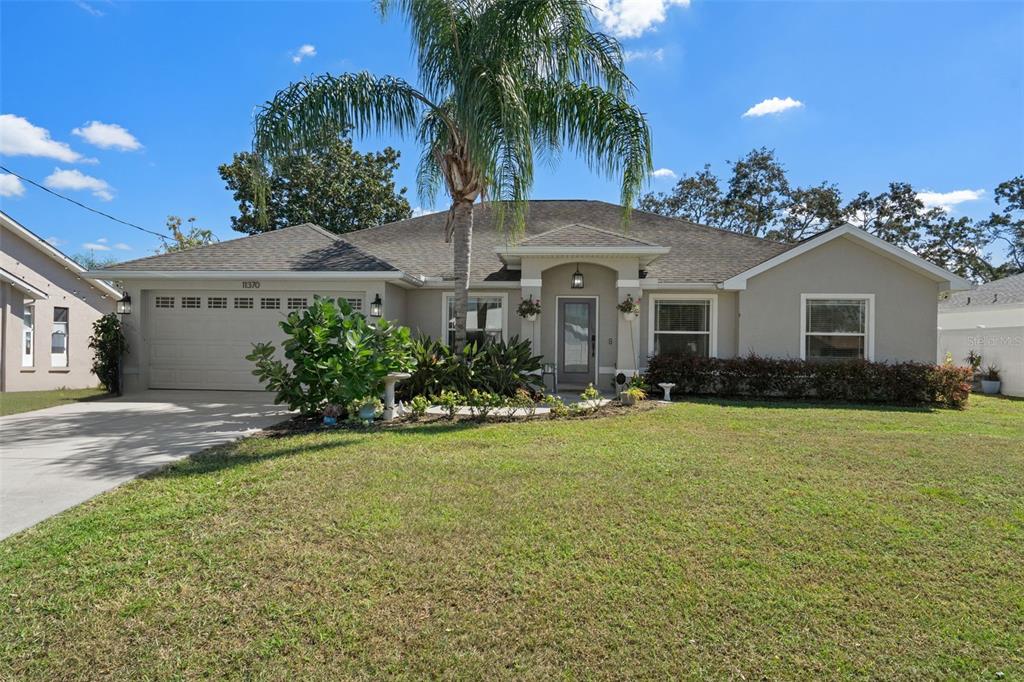 11370 Terrell Road Spring Hill, FL 34608 - Photo 8 of 54 a front view of a house with a garden