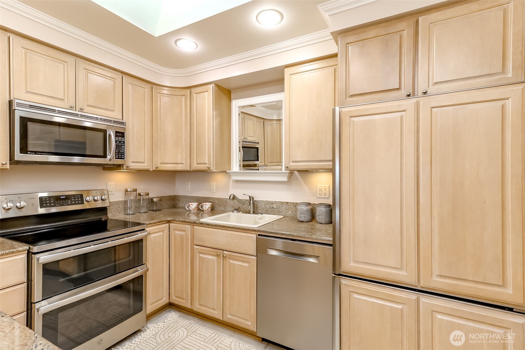 4444 44th Avenue Southwest, Unit 405 Seattle, WA 98116 - Photo 8 of 32 a kitchen with stainless steel appliances white cabinets and a stove top oven
