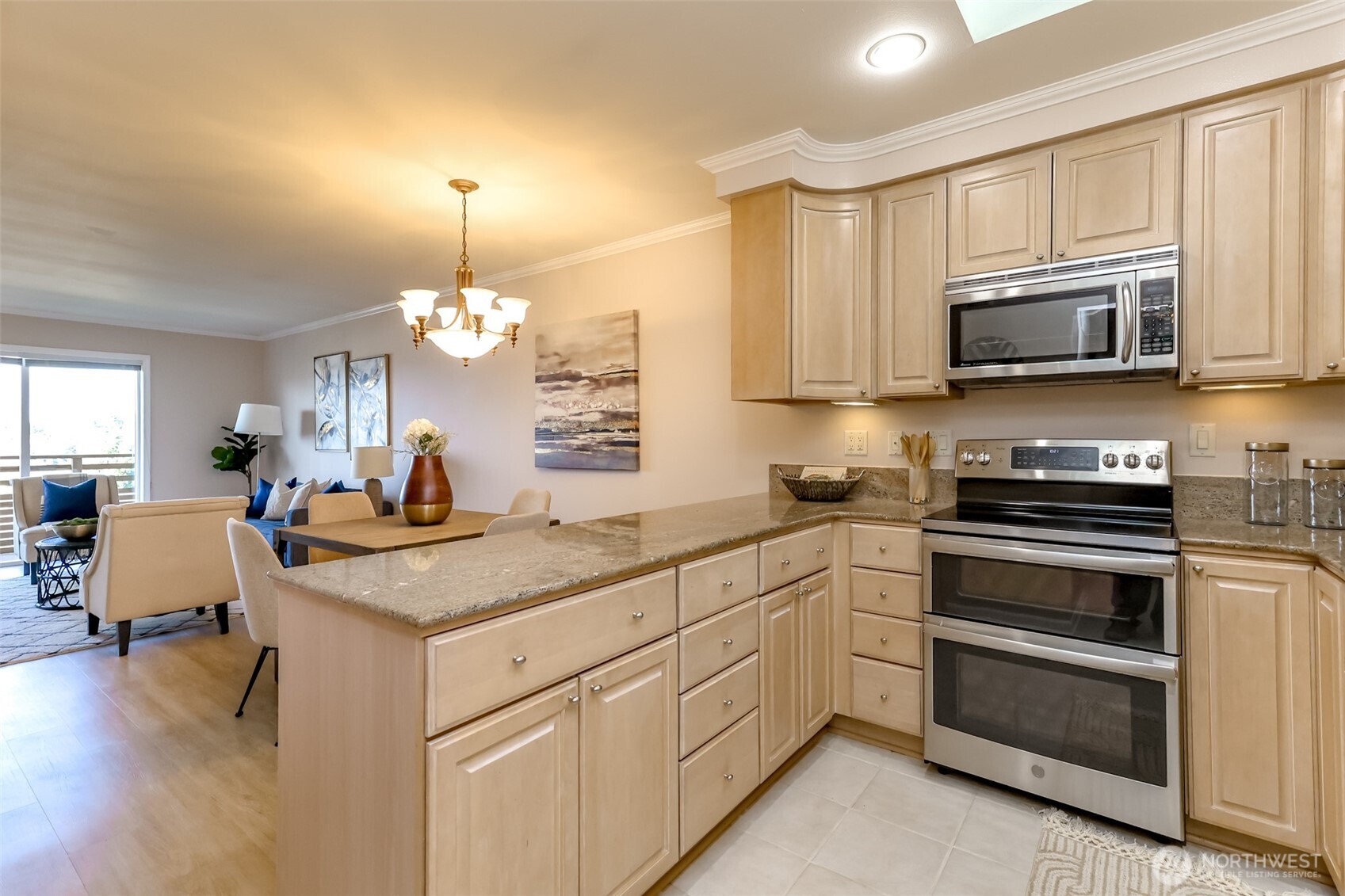4444 44th Avenue Southwest, Unit 405 Seattle, WA 98116 - Photo 9 of 32 a kitchen with kitchen island granite countertop stainless steel appliances a stove sink microwave and cabinets
