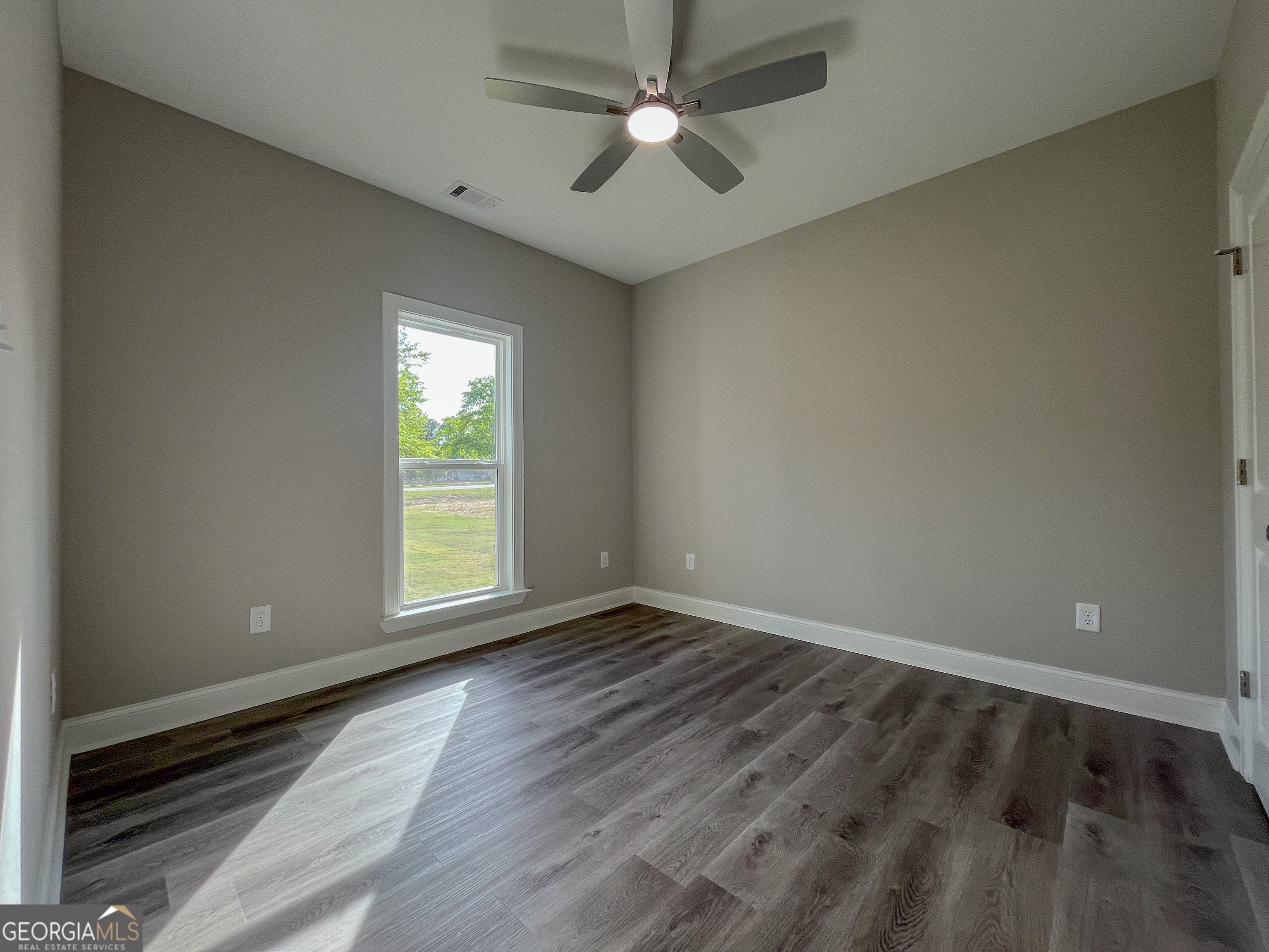 711 Flanders Lane Dublin, GA 31021 - Photo 33 of 49 an empty room with wooden floor and windows