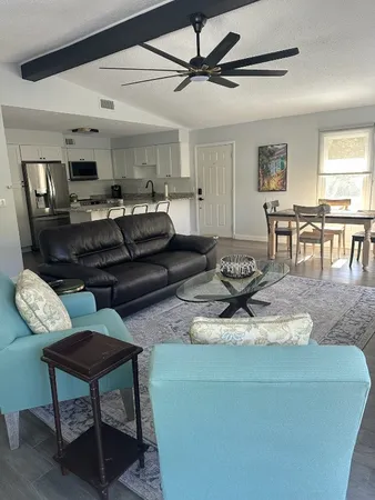 a living room with furniture and a dining table with kitchen view