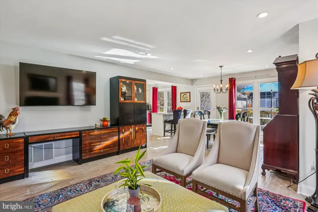 a view of a kitchen with stainless steel appliances granite countertop a stove and a dining table with wooden floor