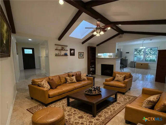 a living room with furniture a fireplace and a flat screen tv