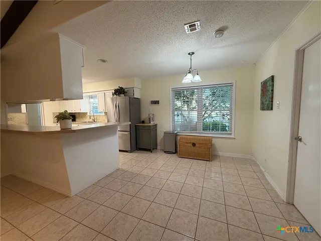 a kitchen with granite countertop a stove a sink and a refrigerator