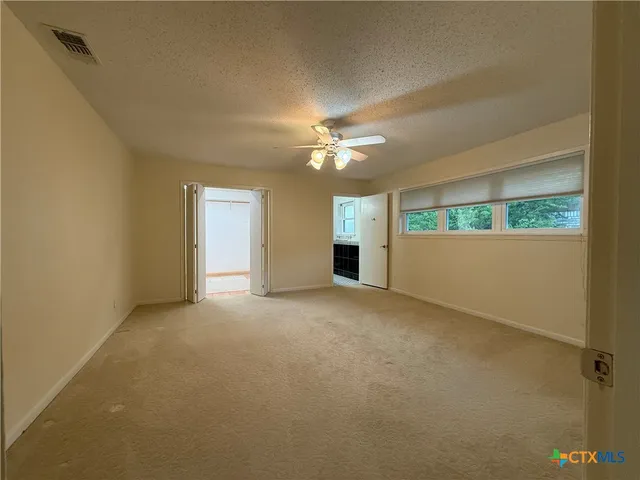 a view of a livingroom with a ceiling fan and window