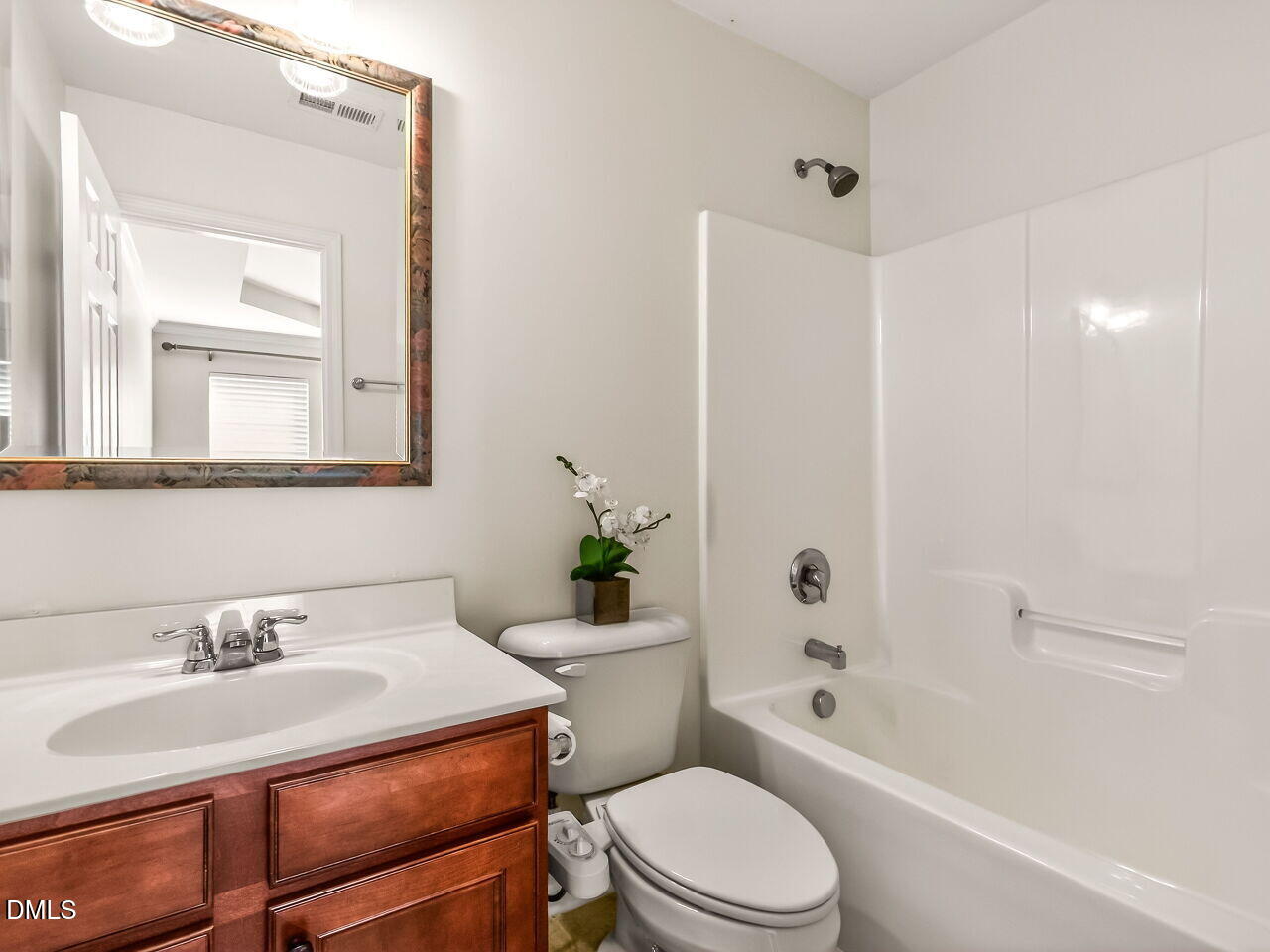 2512 Blooming Street Raleigh, NC 27612 - Photo 28 of 33 a bathroom with a sink toilet a mirror and shower