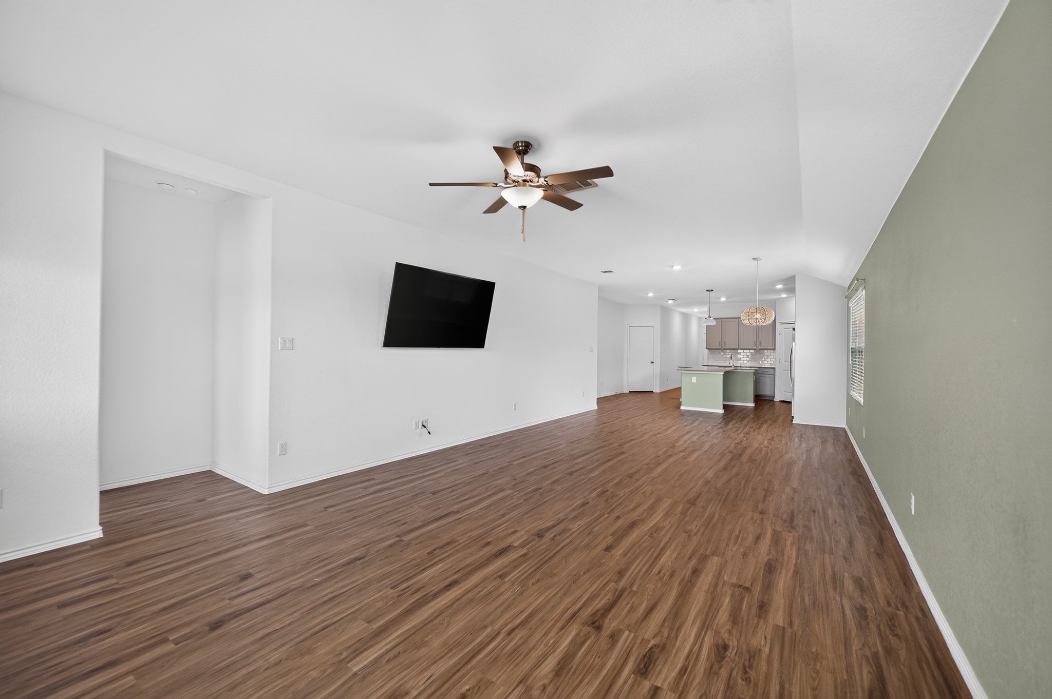 128 Konik Road Georgetown, TX 78626 - Photo 4 of 34 A spacious living area with warm wood flooring flows into a contemporary kitchen, perfect for entertaining.