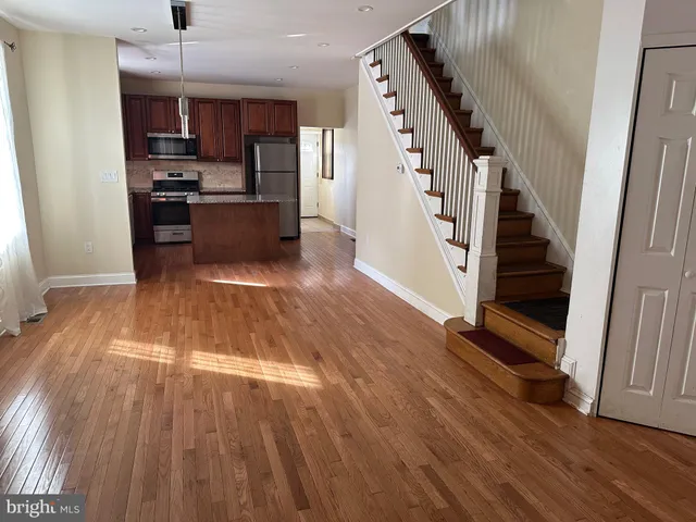 a view of kitchen with sink and refrigerator