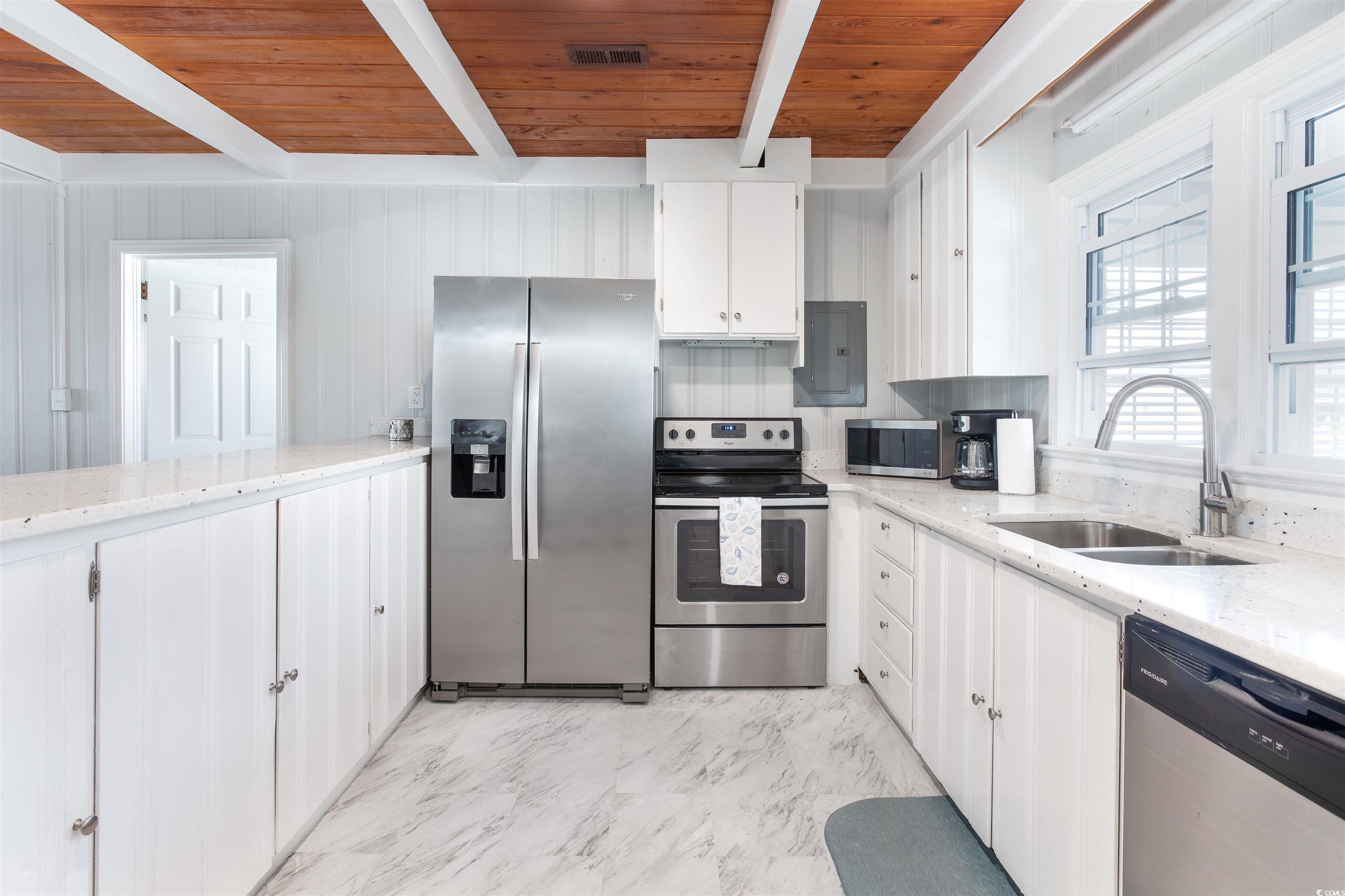 214 Yucca Avenue Murrells Inlet, SC 29576 - Photo 11 of 22 Kitchen with light stone counters, stainless steel appliances, white cabinetry, a wood ceiling with exposed beams, and electric panel