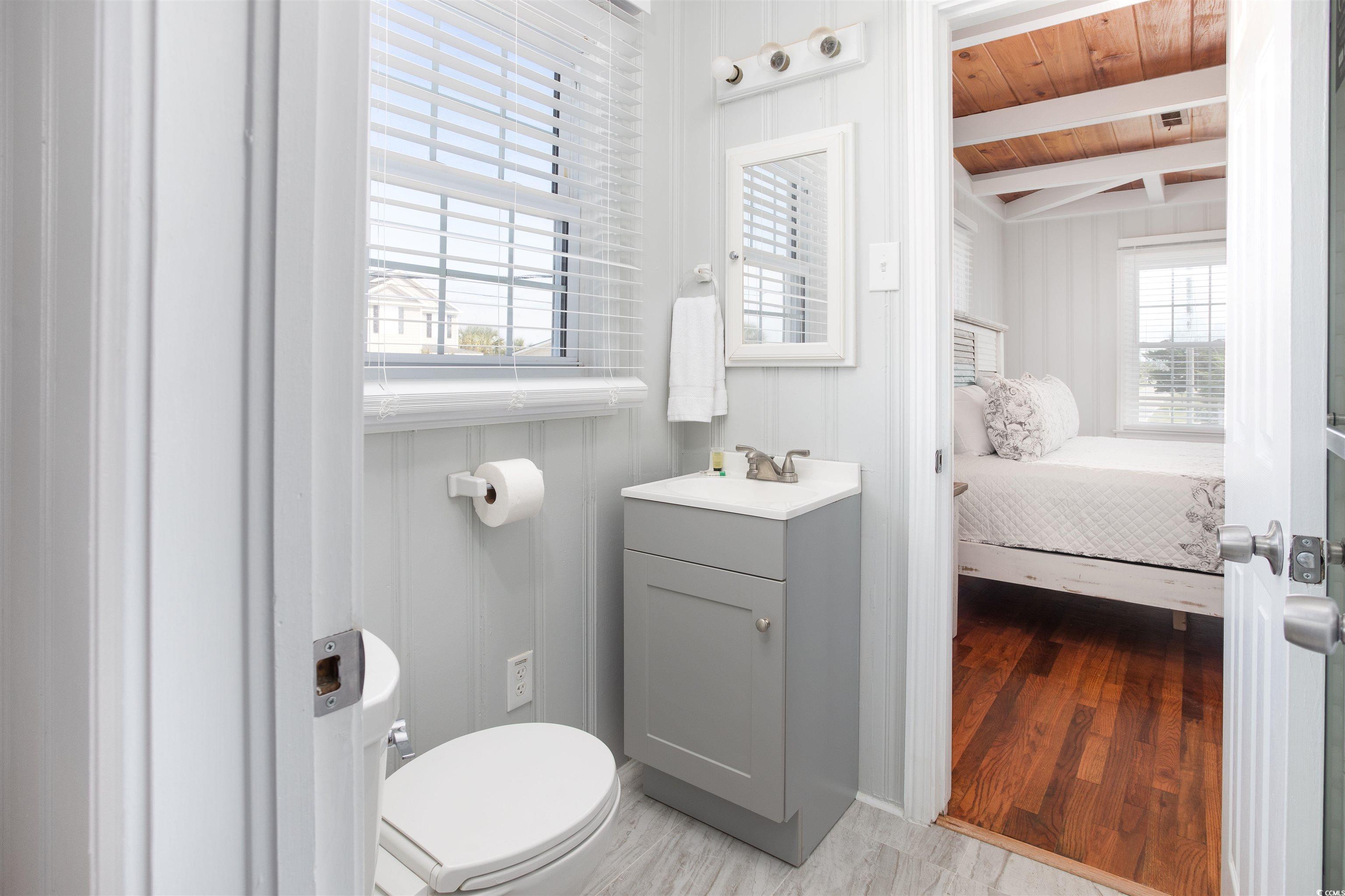 214 Yucca Avenue Murrells Inlet, SC 29576 - Photo 15 of 22 Half bathroom with vanity, light wood-style flooring, and a wooden ceiling with exposed beams
