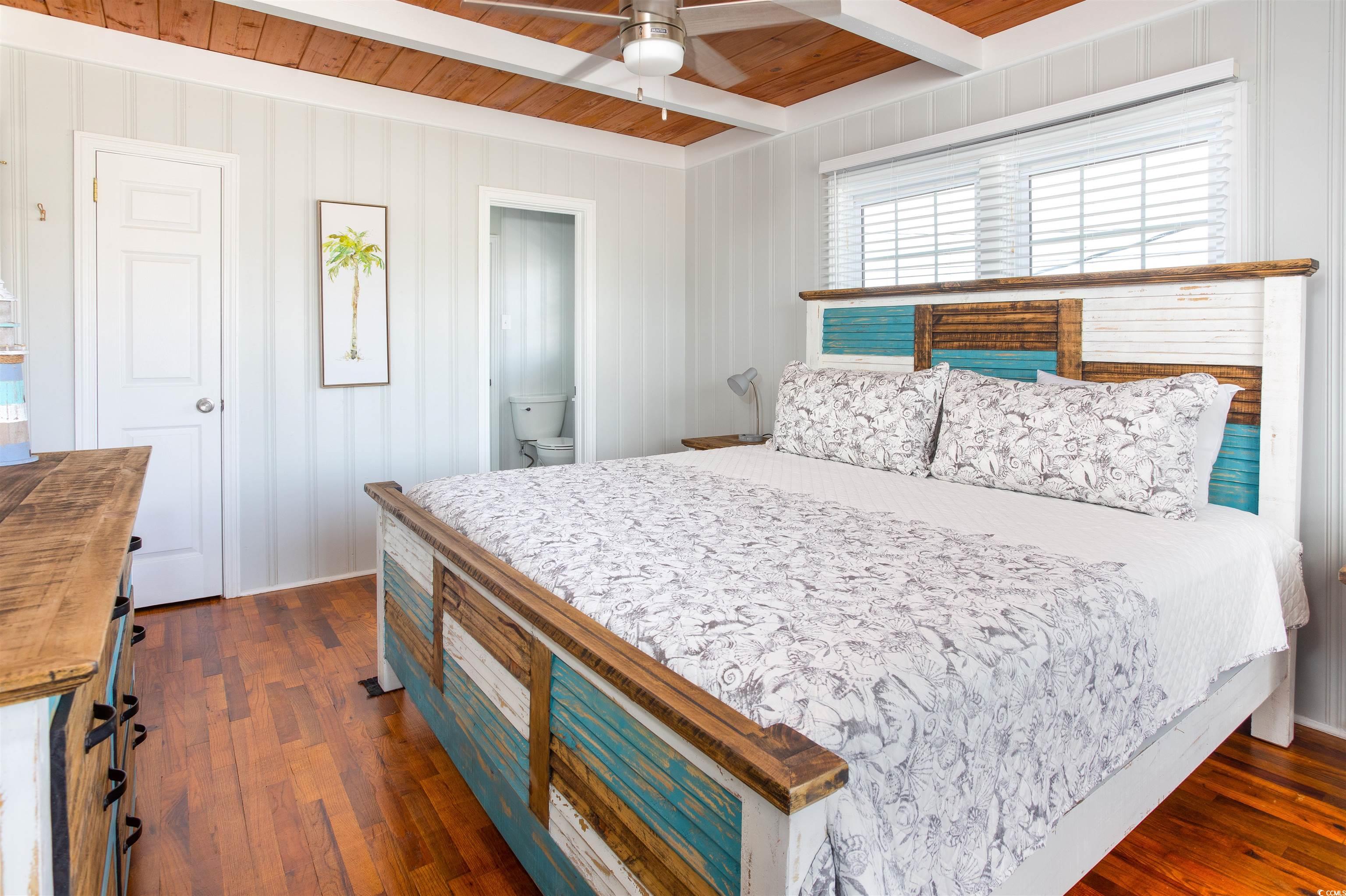214 Yucca Avenue Murrells Inlet, SC 29576 - Photo 17 of 22 Bedroom with a wood ceiling with exposed beams, dark wood-style floors, ceiling fan, and ensuite bathroom