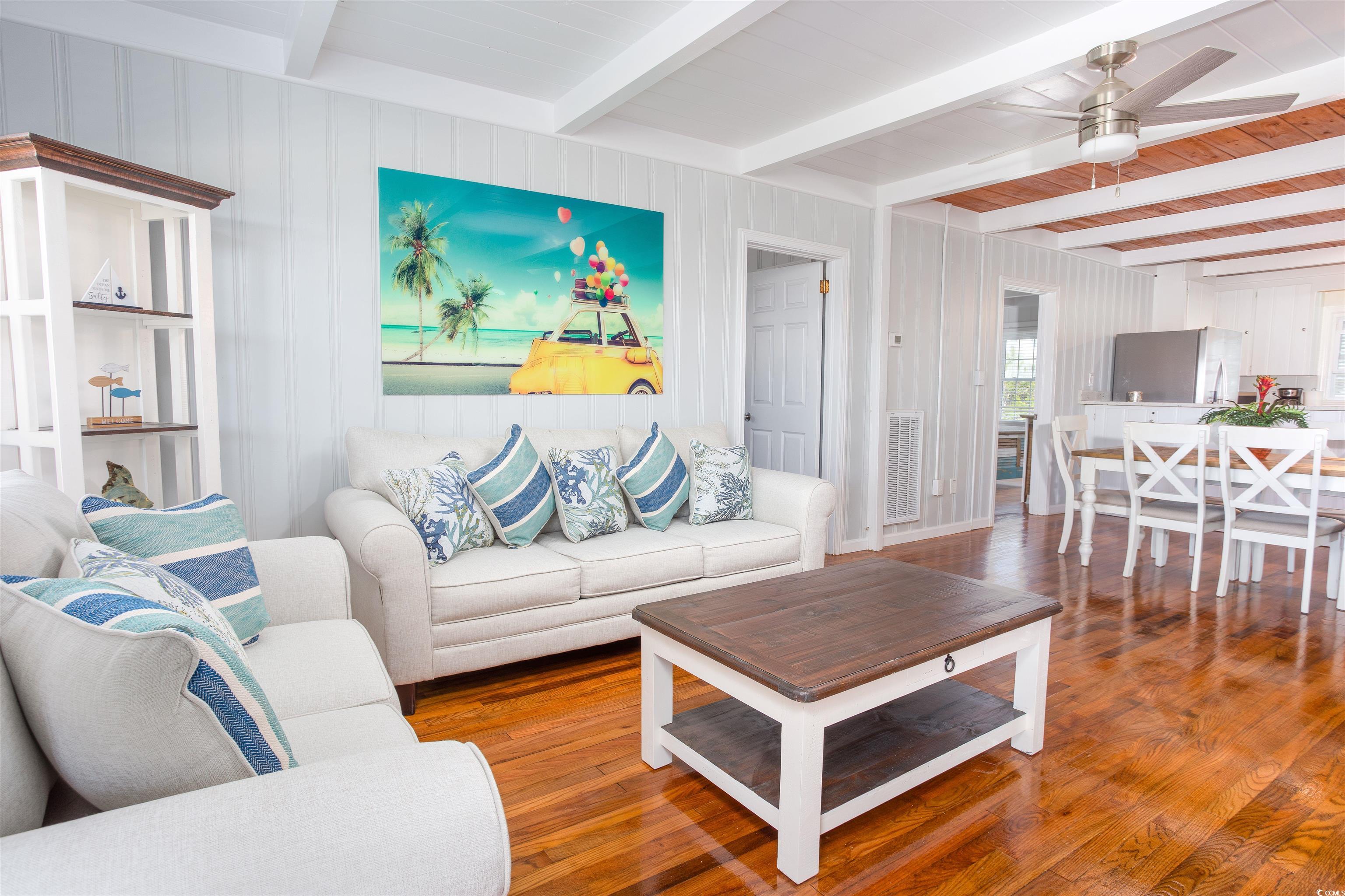 214 Yucca Avenue Murrells Inlet, SC 29576 - Photo 8 of 22 Living room with beamed ceiling, wood finished floors, ceiling fan, and wooden walls