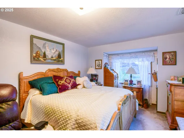 a bedroom with a bed and a painting on the wall